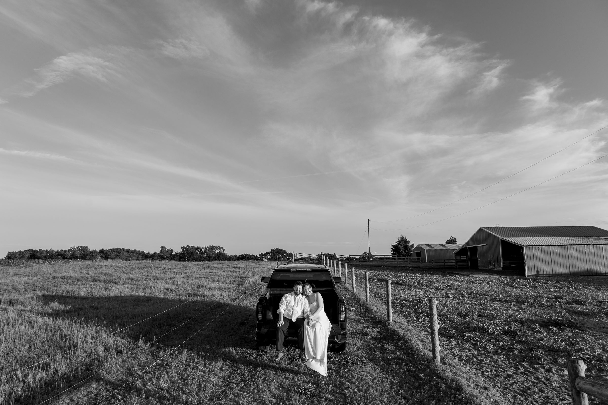 Newlyweds on a truck tailgate overlooking the fields at Ridge View Ranch