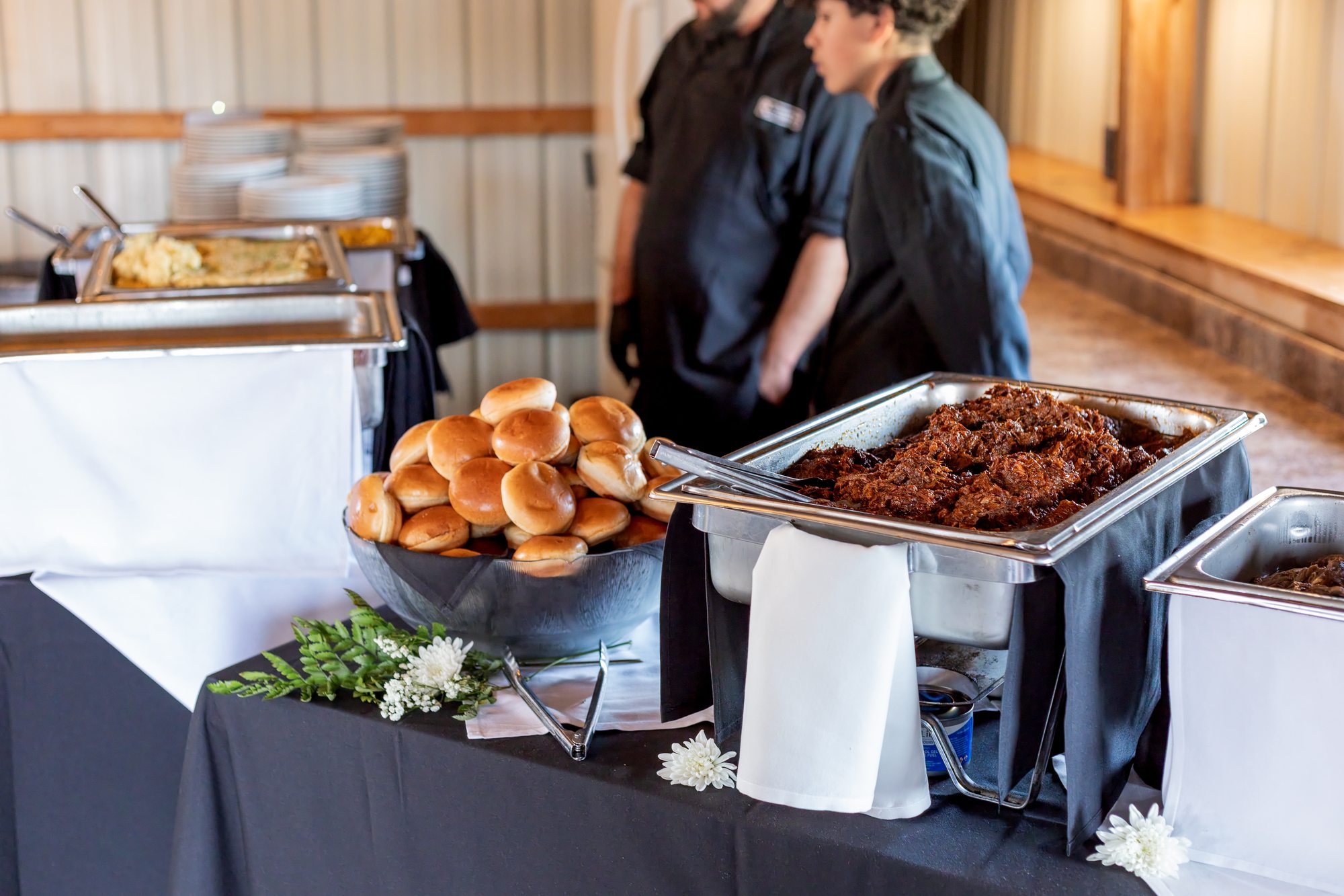 Catered buffet with brisket, pulled pork and rolls at a Ridge View Ranch wedding reception