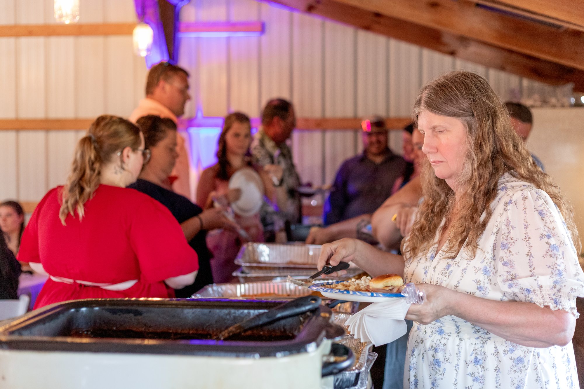 Wedding guests going through the buffet line in the reception barn at Ridge View Ranch