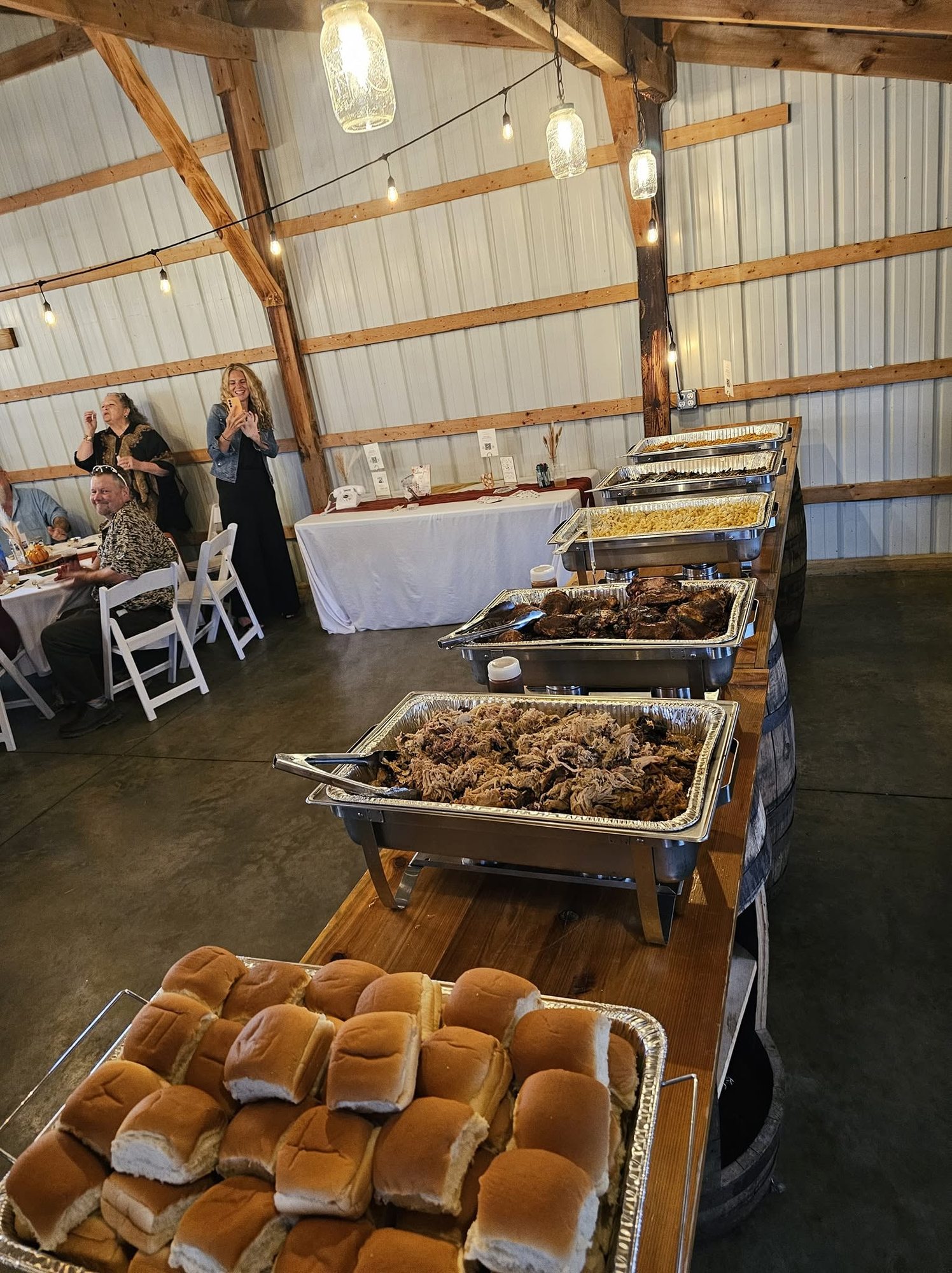 Buffet set on wine barrels and planks in the reception barn at Ridge View Ranch