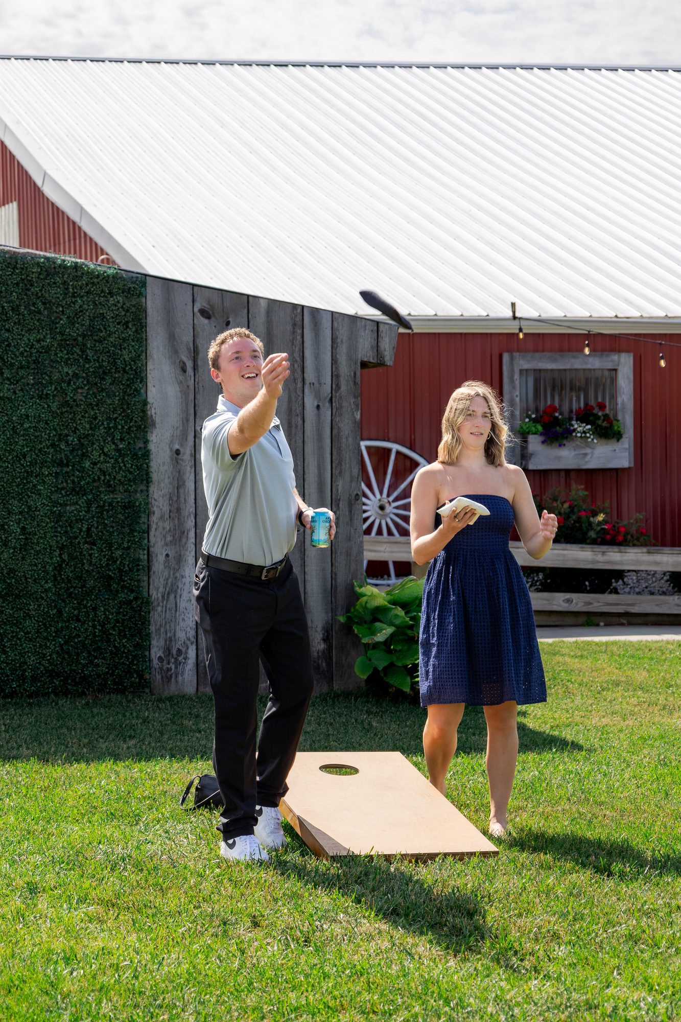 Wedding guests playing cornhole on the lawn at Ridge View Ranch in Kent City, Michigan