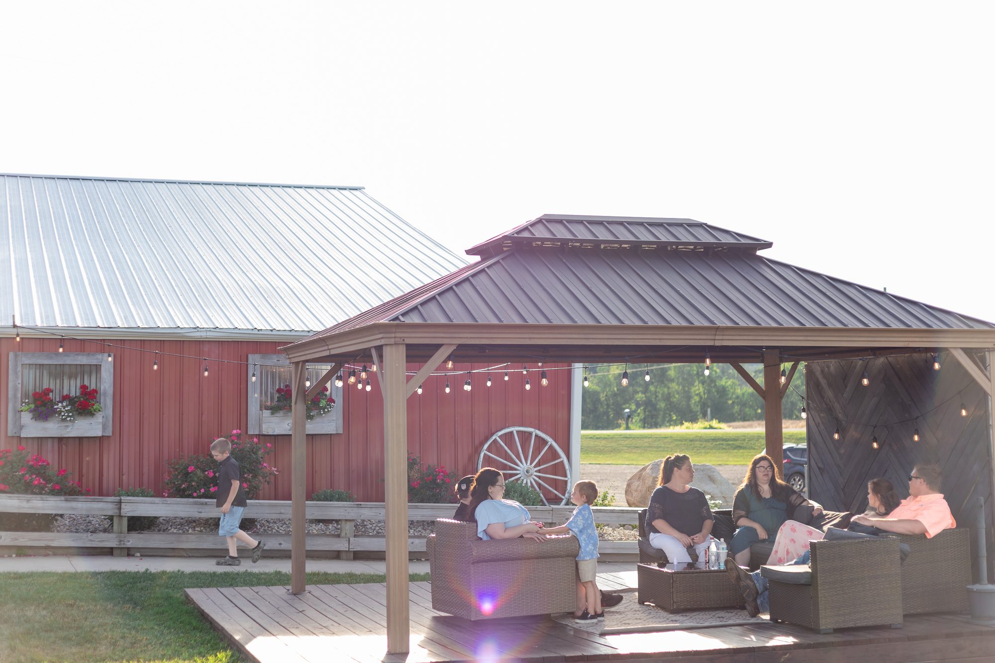 Guests relaxing under the gazebo lounge at Ridge View Ranch barn wedding venue