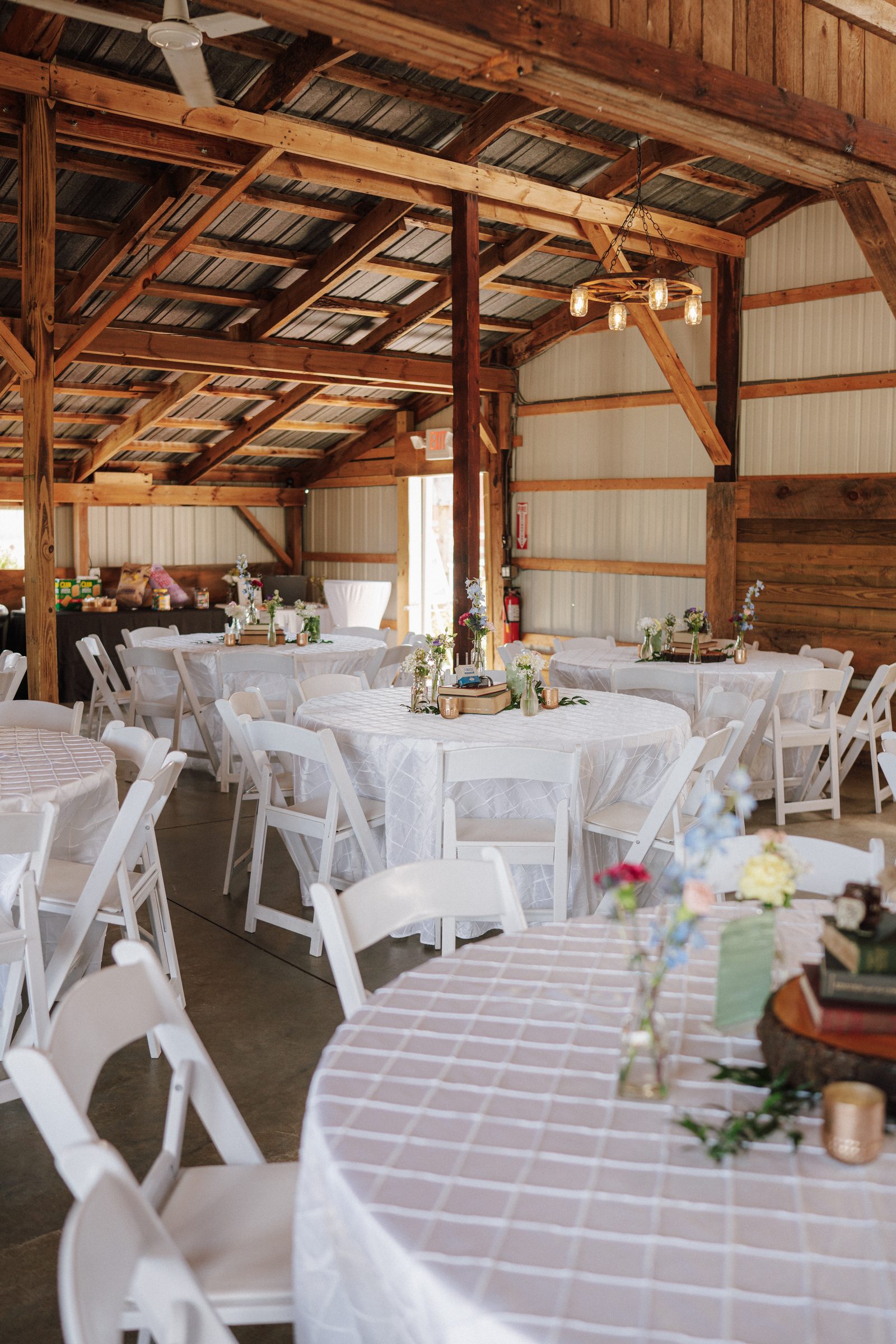 Reception barn set with round tables and white chairs at Ridge View Ranch